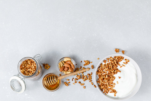 Homemade oatmeal granola bowl  on ligth grey background. Healthy breakfast concept. Organic oat, almond and sunflower seeds. Top view, flat lay, copy space