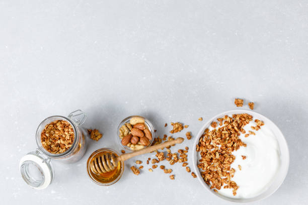 домашняя овсяная мюсли с мюсли на сером фоне. концепция здорового завтрака. органические семена овса, миндаля и подсолнечника. плоская укла - bowl cereal cereal plant granola стоковые фото и изображения