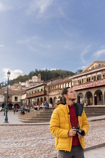 Tourist in the main square of cuzco, holding his camera.