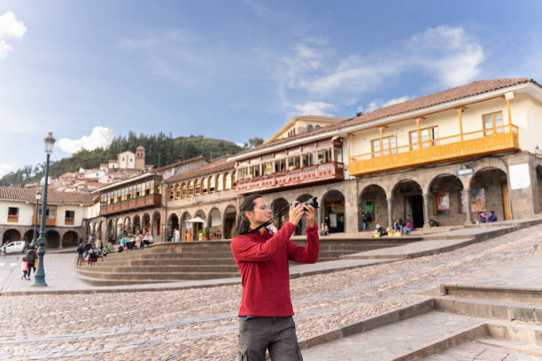 turista tomando una foto en la plaza principal de cuzco - provincia de cuzco fotografías e imágenes de stock