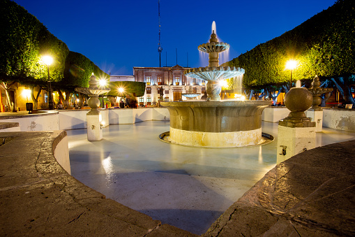April 20, 2022. Queretaro, Mexico. View of the Jardin Guerrero fountain at night, where people can be seen living on a daily basis after two years of the pandemic. The Guerrero Garden is a meeting place for Queretaro artists, who expose their creations to the curious gaze of visitors.