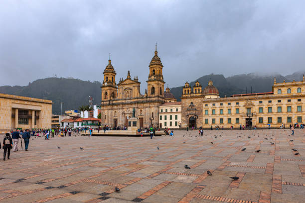 Bogota, Colombia - The Northeastern Corner Of Plaza Bolivar With Ninteenth Century Catedral Primada, The Seat Of The Roman Catholic Archbishop Of Colombia, Casa Del Florero And Capilla Del Sagrario, With The Andes Mountains In The Background. stock photo