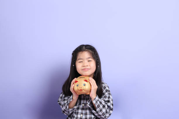 Little girl looking at piggy bank