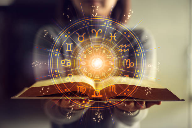 Woman holding a astrology book. Astrological wheel projection, choose a zodiac sign. Astrology esoteric concept. Woman holding a astrology book. Astrological wheel projection, choose a zodiac sign. Astrology esoteric concept. astrology stock pictures, royalty-free photos & images