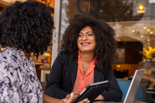Transgender woman and her business partner working at cafe stock photo