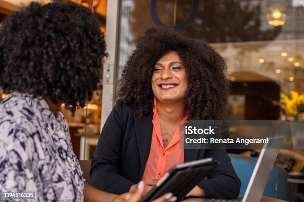 Transgender Woman And Her Business Partner Working At Cafe Stock Photo - Download Image Now