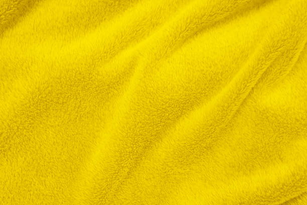 istock Yellow clean wool texture background. light natural sheep wool. yellow seamless cotton. texture of fluffy fur for designers. close-up fragment white wool carpet. 1394517216