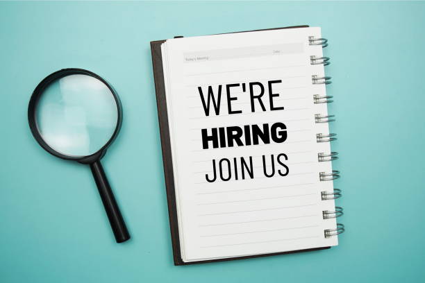 istock We are Hiring text on notepad and magnifying glass on blue background 1394520456