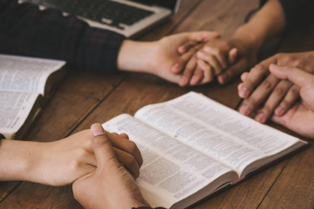 istock Group of different women praying together, Christians and Bible study. Begging for forgiveness and believe in goodness. Christian life crisis prayer to god. 