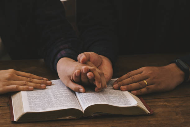 dos amantes oran por la bendición de dios para desear tener una vida mejor. manos de mujer orando a dios con la biblia. pidiendo perdón y creyendo en la bondad. oración de crisis de vida cristiana a dios. - buddhist puja fotografías e imágenes de stock