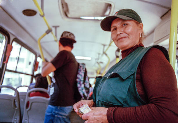 Portrait of a worker with passengers commuting by public transport Trujillo - June 16, 2016 : Portrait of a worker in the interior of bus with passengers commuting by public transport cash in transit vehicle stock pictures, royalty-free photos & images