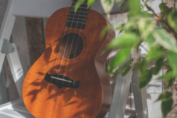 istock Ukulele stand at chair at home with plant. 1394530224