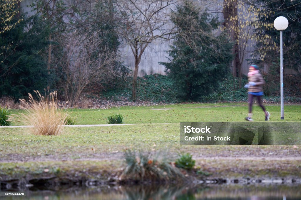Path near Lake. A female jogger in the park. Woman motion blurred. Healthy lifestyle with exercise. Germany, Stuttgart, Schlossgarten. Active Lifestyle Stock Photo
