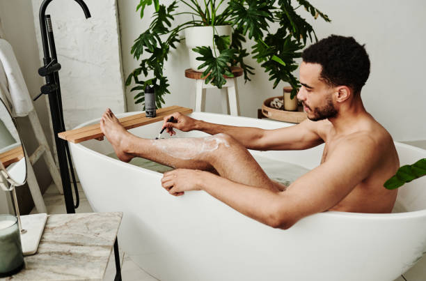 istock Man shaving his legs in bath 1394533430