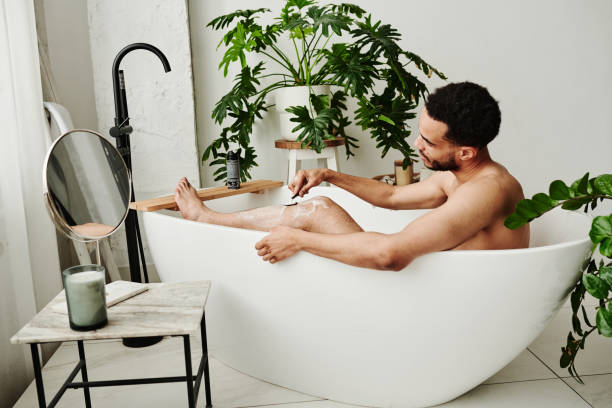istock Man shaving his legs in bathroom 1394533433