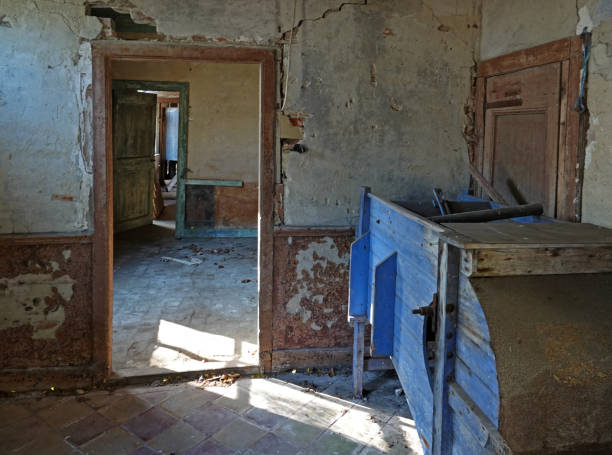 A room from a lost place Old dilapidated rooms. The sunlight shines in through the window. You can see the following rooms through the doors. Holes in the wall. A lost place in Germany. abandoned place stock pictures, royalty-free photos & images