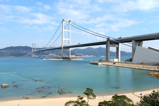 Sandy Ma Wan Tung Wan beach, Ma Wan island, by the Tsing Ma Bridge, a suspension bridge which connects the two islands of Tsing Yi and Ma Wan. The bridge has a main span of 1,377 metres. Hong Kong