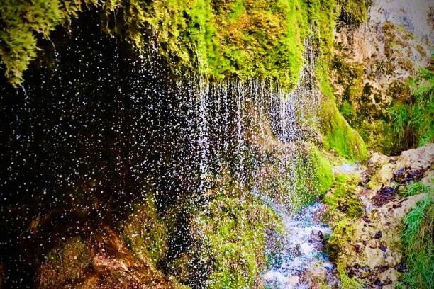 Cave entrance under small waterfall