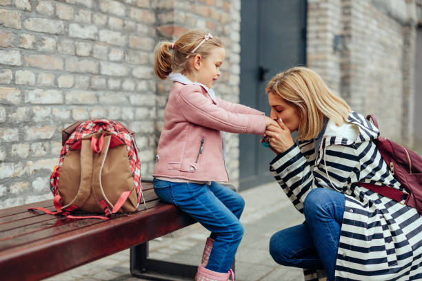 istock Mother kissing her daughter hands 1394545125