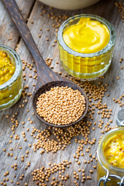 istock Different types of mustard and mustard seeds on a rustic wooden board 1394551908