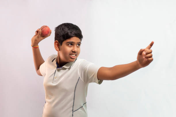 istock A boy in cricket uniform standing Holding a ball 1394554469