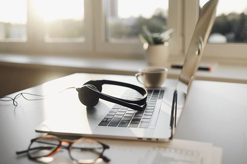 Lugar de trabajo en la oficina, auriculares, computadora portátil, gafas en el escritorio de la oficina photo