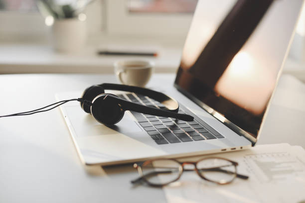 istock Work place in office, headset, laptop computer, glasses at office desk 1394554579