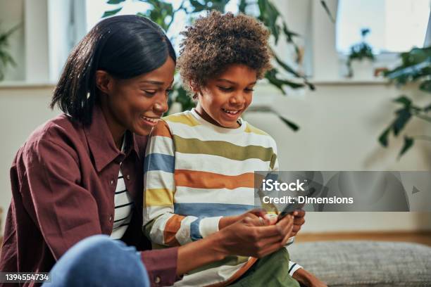 Boy And Mom Having Fun While Using Phone At Home Stock Photo - Download Image Now - Child, Back to School, Education