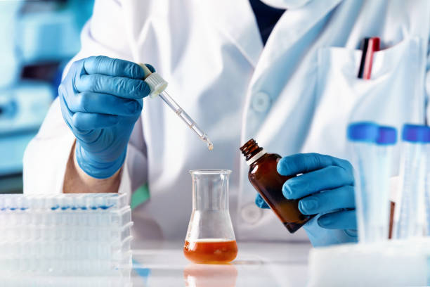 Scientist researcher dosing and mixing fluids in the chemistry lab stock photo