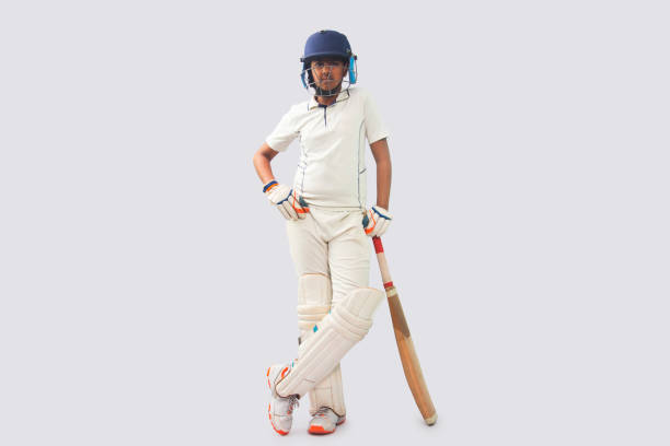 istock full length of a boy in cricket uniform  standing with bat 1394555937