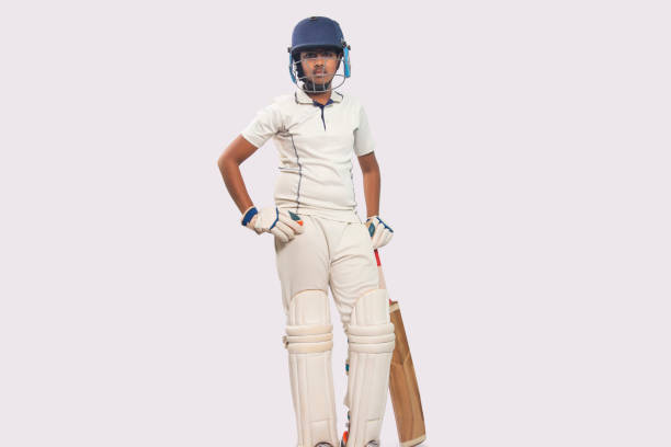 istock full length of a boy in cricket uniform  standing with bat 1394556052
