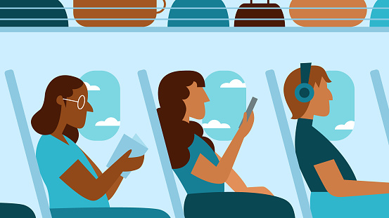 Three multiracial women passengers enjoy an airplane flight while reading a book, using a smartphone and listening to music with headphones.
