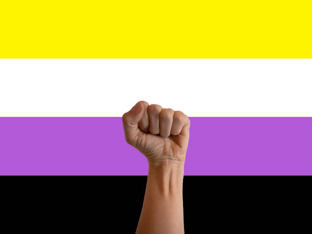 istock A fist raising up to celebrate, background non-binary pride flag 1394560989