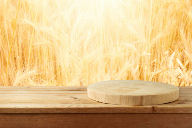 istock Empty wooden log on table over wheat blurred background. Shavuot holiday mock up for design and product display 1394563302
