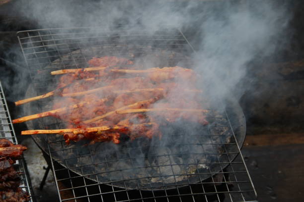 istock Chicken grilling on black grate, Thailand. 1394564506