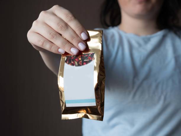 istock The girl holds in her hand pulls forward a paper bag with tea with a place for a layout, an impersonal photo 1394566720