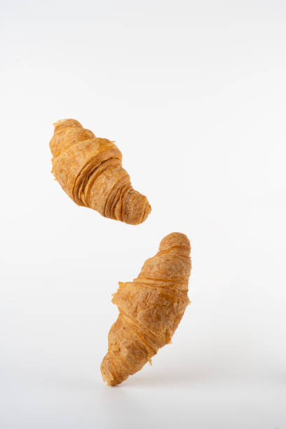 istock flying fresh croissants on a white background 1394566973