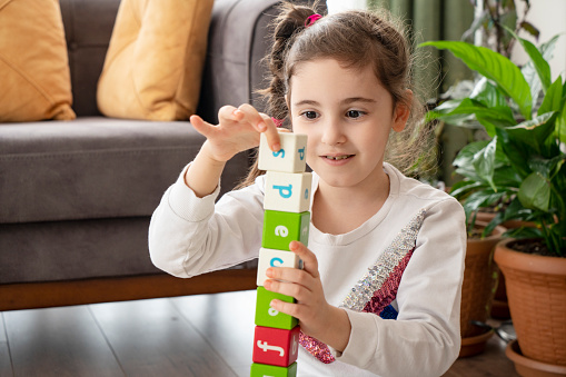 Kid playing with colorful blocks at home