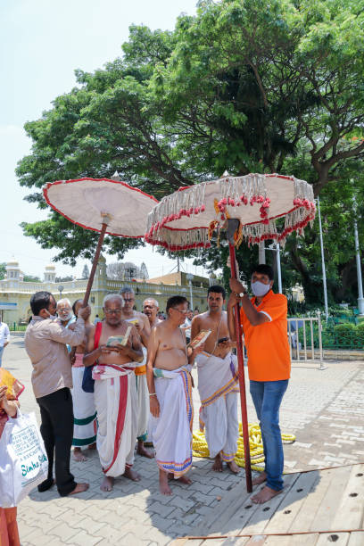 un gruppo di sacerdoti indù recitano versi religiosi per il festival di shiva fuori da un tempio di vishnu in una giornata di sole a mysore, in india. - indian ethnicity traditional culture architecture karnataka foto e immagini stock