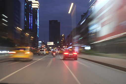 Colorful light trails during city night travel by car fast going