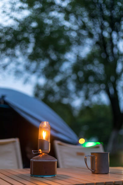 istock Camping night outdoors with retro lights and dining table 1394593756