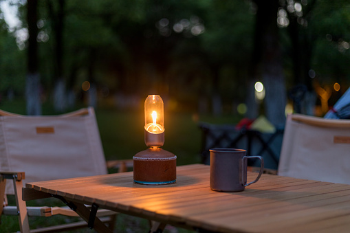 Camping night outdoors with retro lights and dining table