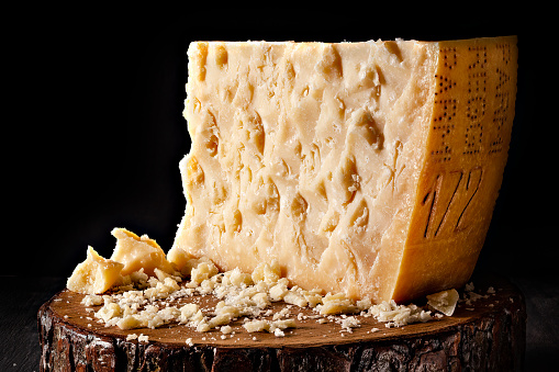 An aged authentic parmigiano reggiano - parmesan cheese on rustic wood
