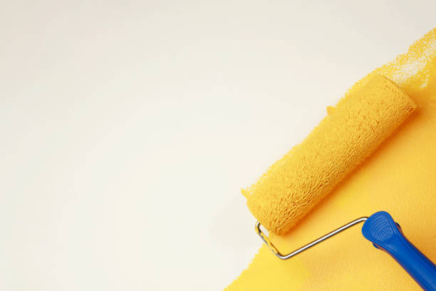 istock Painter is painting the interior wall yellow 1394596027