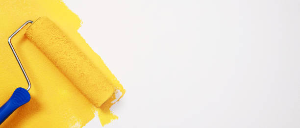 istock Painter is painting the interior wall yellow 1394596028