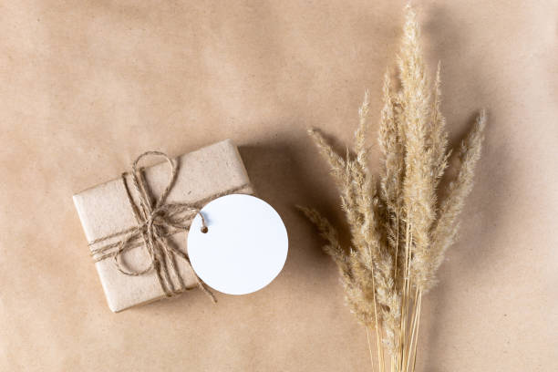 istock empty white gift tag mock up on craft paper box with dried spikelets decoration on natural beige background. 1394601083