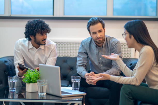 Team of coworkers holding their meeting in a modern office stock photo