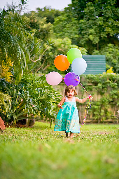 little girl running with balloons stock photo