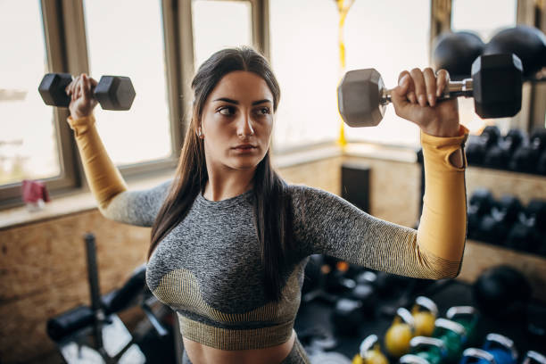 istock Young woman training with dumbbells 1394604867