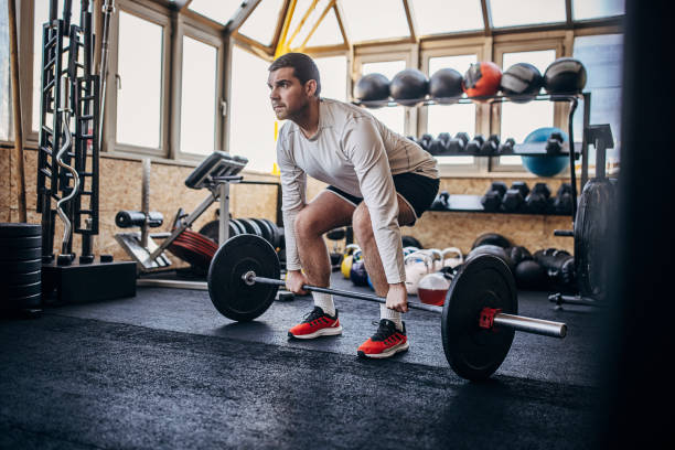 allenamento dell'uomo in palestra - crouching barbell weightlifting weight training foto e immagini stock